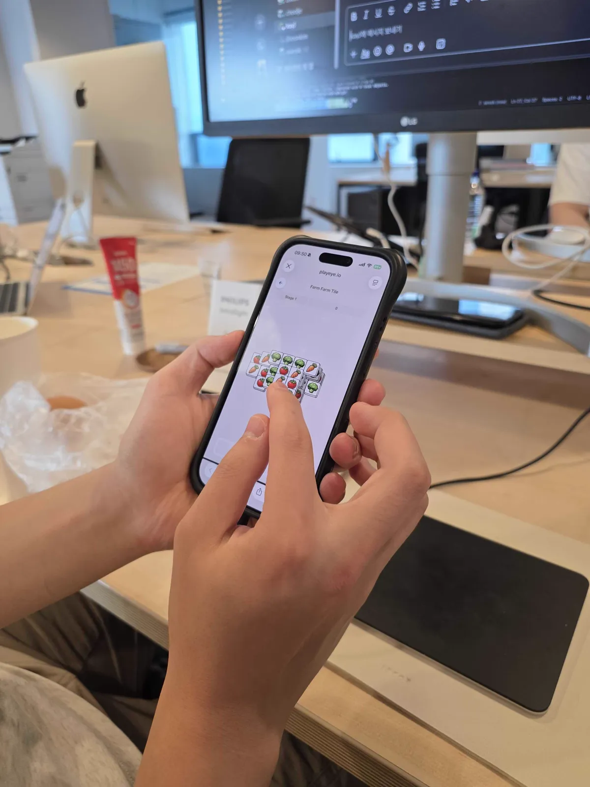 Close view of a player tapping a vegetable tile in Farm Farm Tile with the right index finger while holding the phone with both hands